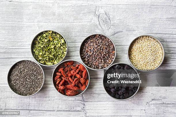 bowls of chokeberries, chia, cocoa, quinoa, moringa and wolfberries - moringa stock pictures, royalty-free photos & images