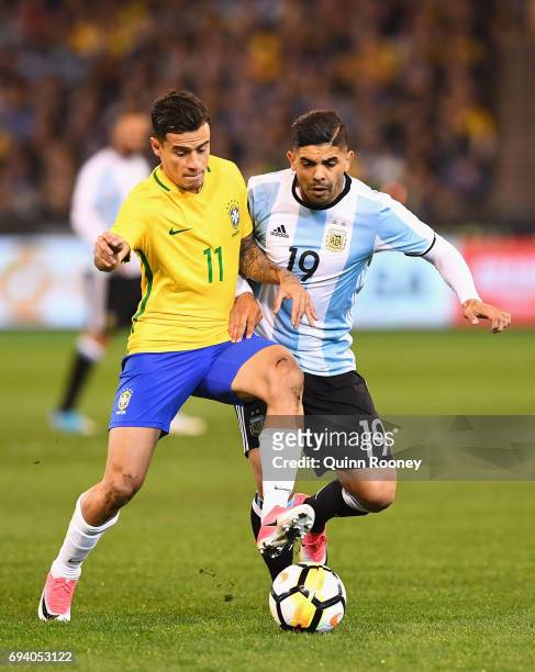 Philippe Coutinho of Brazil and Ever Banega of Argentina compete for the ball during the Brazil Global Tour match between Brazil and Argentina at...