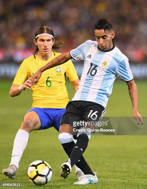 Jose Luis Gomez of Argentina passes the ball infront of Kasmirski Filipe Luis of Brazil during the Brazil Global Tour match between Brazil and...