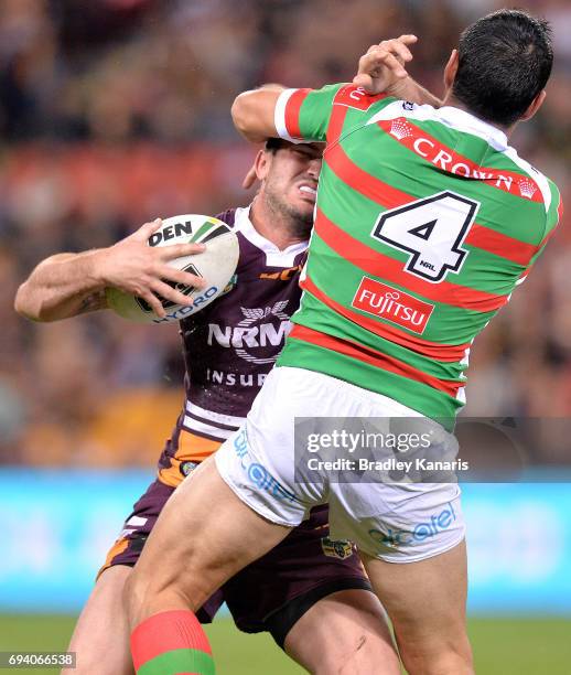 Matt Gillett of the Broncos attempts to break free from the defence of Bryson Goodwin of the Rabbitohs during the round 14 NRL match between the...