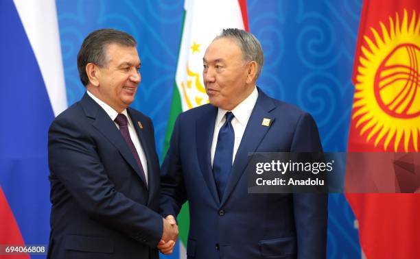 Uzbekistan's President Shavkat Mirziyoyev and Kazakhstan's President Nursultan Nazarbayev shake their hands ahead of a meeting of the Shanghai...