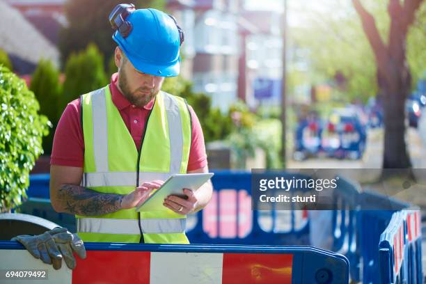 construction worker at a road dig - repairing road stock pictures, royalty-free photos & images