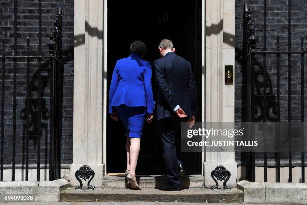 Britain's Prime Minister and leader of the Conservative Party Theresa May, accompanied by her husband Philip, leaves after delivering a statement...