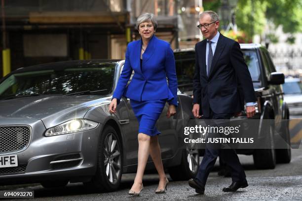 Britain's Prime Minister and leader of the Conservative Party Theresa May, accompanied by her husband Philip, arrives to deliver a statement outside...