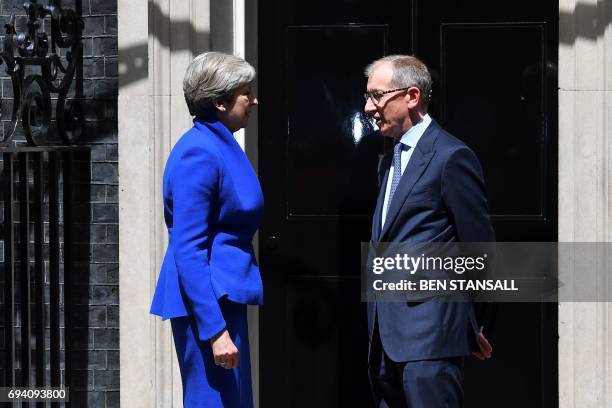 Britain's Prime Minister and leader of the Conservative Party Theresa May, accompanied by her husband Philip, leaves after delivering a statement...