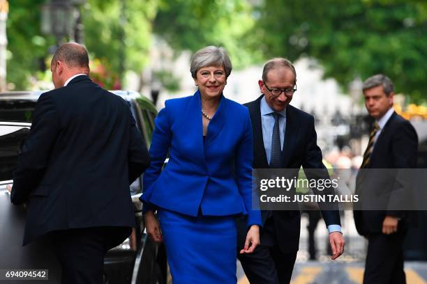 Britain's Prime Minister and leader of the Conservative Party Theresa May, accompanied by her husband Philip, arrives to deliver a statement outside...