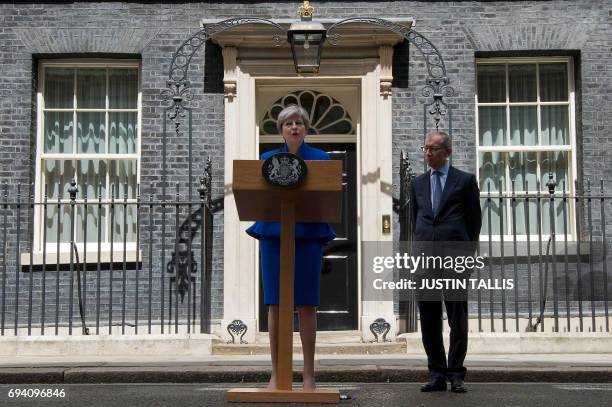 Britain's Prime Minister and leader of the Conservative Party Theresa May, accompanied by her husband Philip, delivers a statement outside 10 Downing...