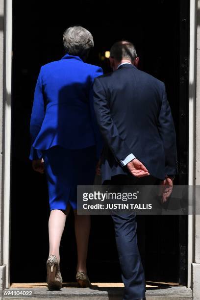 Britain's Prime Minister and leader of the Conservative Party Theresa May, , and her husband Philip , walk inside 10 Downing Street after the prime...
