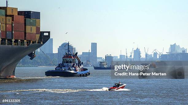 tugboat and container vessel, hamburg, germany - schlepper stock-fotos und bilder