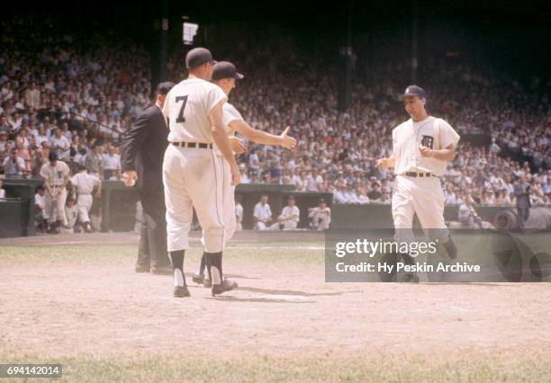 Charlie Maxwell of the Detroit Tigers is congratulated by teammates Al Kaline and Harvey Kuenn after hitting a homerun during an MLB game against the...