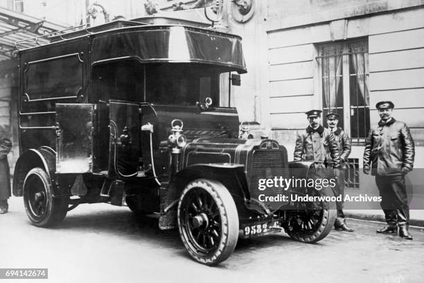 Portrait of a group of bank guards and their armored car, Paris, France, circa 1913. The armored truck was brought into service as a result of recent...