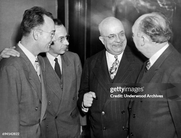 At the Waldorf-Astoria, Kaiser-Frazer Corporation chairman Henry J Kaiser and journalist Robert Elliott talk together as the former's sons, Henry J...