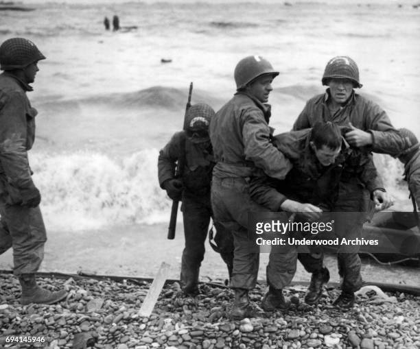 Unidentified survivors from a sunken LCVP are helped ashore at Omaha Beach during the invasion of Normandy, Normandy, France, June 6, 1944.