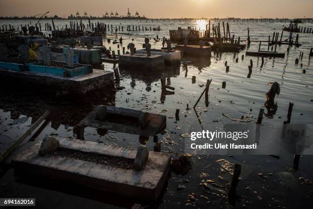 View of public cemetery which submerged by flood waters from rising sea levels on June 8, 2017 in Semarang, Indonesia. Indonesia is known to be one...