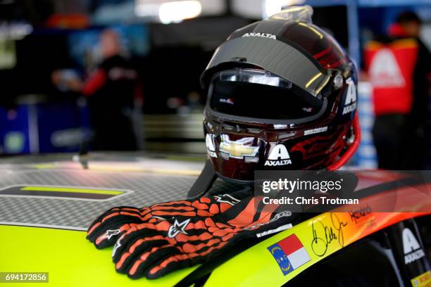The gloves and helmet of Dale Earnhardt Jr., driver of the Axalta Chevrolet, sit on top of his car during practice for the Monster Energy NASCAR Cup...