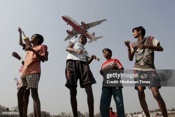 Kids at Vile Parle slums surrounding the airport participate in the annual kite flying festival on the occasion of Makar Sankranti .