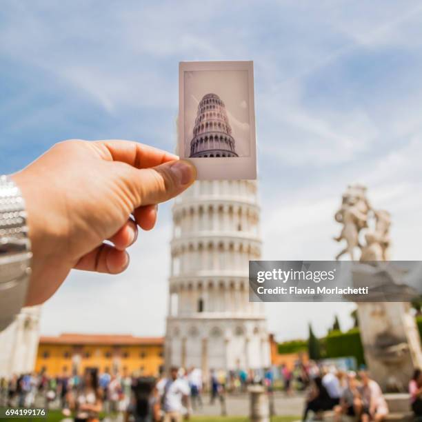 man's hand holding an instant photo against the leaning tower of pisa - torre de pisa imagens e fotografias de stock