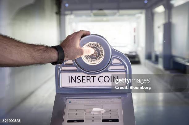 Man inserts a coin into the Carvana Co. Car vending machine in Frisco, Texas, U.S., on Thursday, June 8, 2017. The U.S. Automotive industry may be...