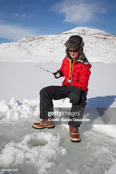 senior man ice fishing for trout - deerstalker hat imagens e fotografias de stock