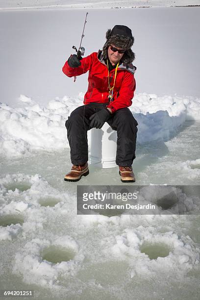 ice fisherman fishing with multiple holes - deerstalker hat imagens e fotografias de stock