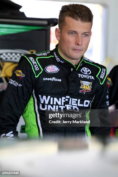 Dakoda Armstrong, driver of the WinField United Toyota, stands in the garage area during practice for the NASCAR XFINITY Series Pocono Green 250 at...