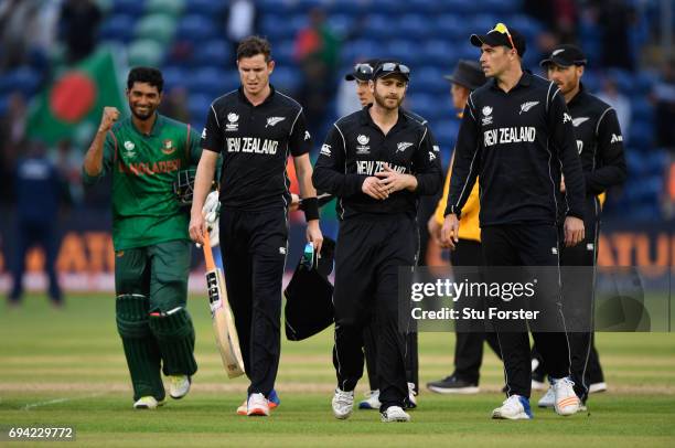 New Zealand captain Kane Williamson leads his team off the field as Bangladesh batsman Mahmudullah celebrates victory after the ICC Champions Trophy...