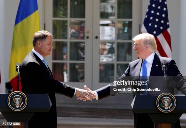 President Donald Trump shakes hands with Romanian President Klaus Iohannis as they hold a joint news conference in the Rose Garden at the White House...