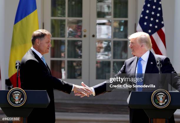 President Donald Trump shakes hands with Romanian President Klaus Iohannis as they hold a joint news conference in the Rose Garden at the White House...