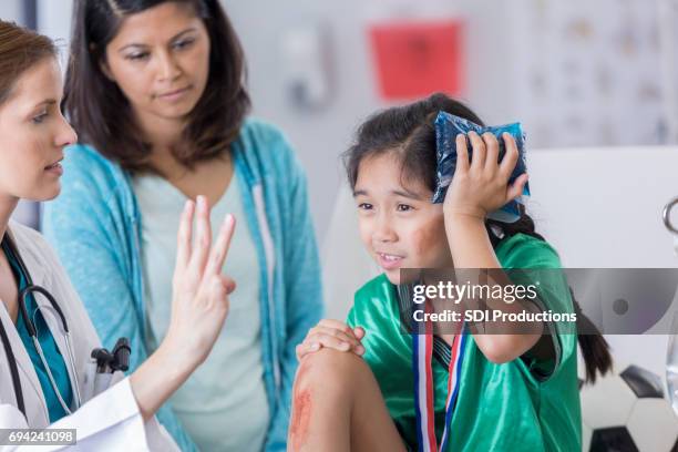 doctor er examina aturdido futbolista lesionado - herida fotografías e imágenes de stock