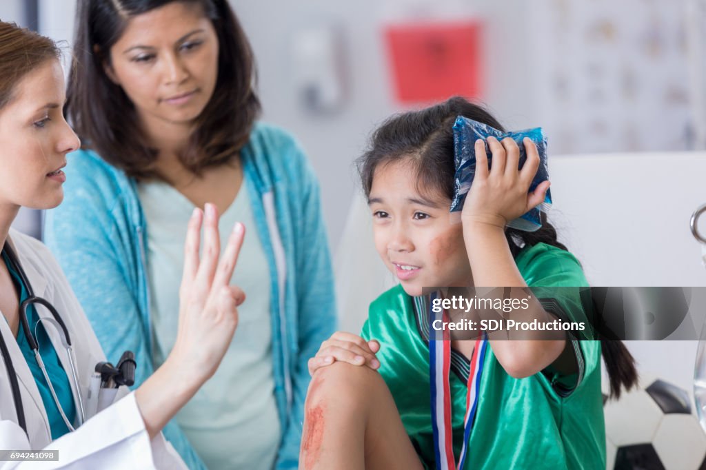 ER doctor examines dazed injured soccer player