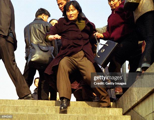 Chinese plainclothes police drag a woman January 24, 2002 toward the subway of Beijings Tiananmen Square. At least two women were arrested in the...