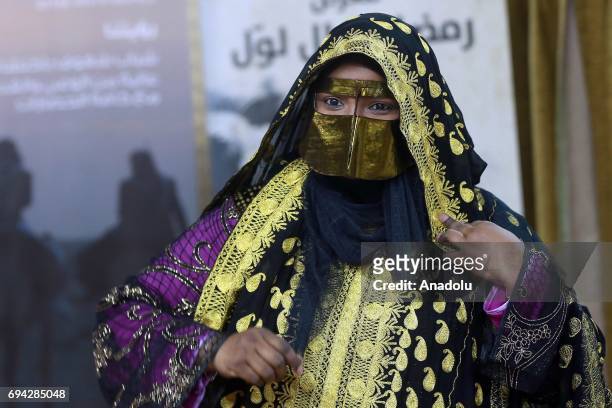 Woman in traditional clothes is seen during a traditional event named "Garangaou", organized within Muslims' holy month of Ramadan in Doha, Qatar on...