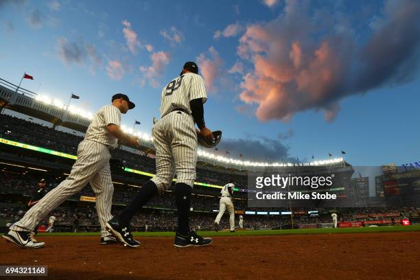 Aaron Judge and Matt Holliday of the New York Yankees take the field for the start of the second inning against the Baltimore Orioles at Yankee...