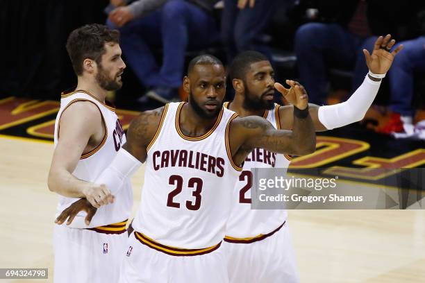 Kevin Love, LeBron James and Kyrie Irving of the Cleveland Cavaliers react after a play in the first quarter against the Golden State Warriors in...