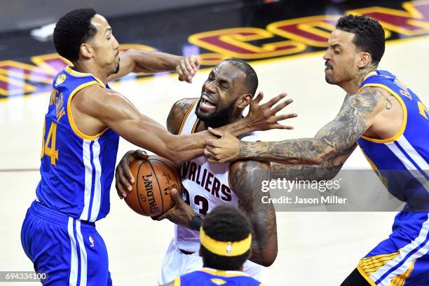 LeBron James of the Cleveland Cavaliers drives to the basket against Shaun Livingston and Matt Barnes of the Golden State Warriors in the first...