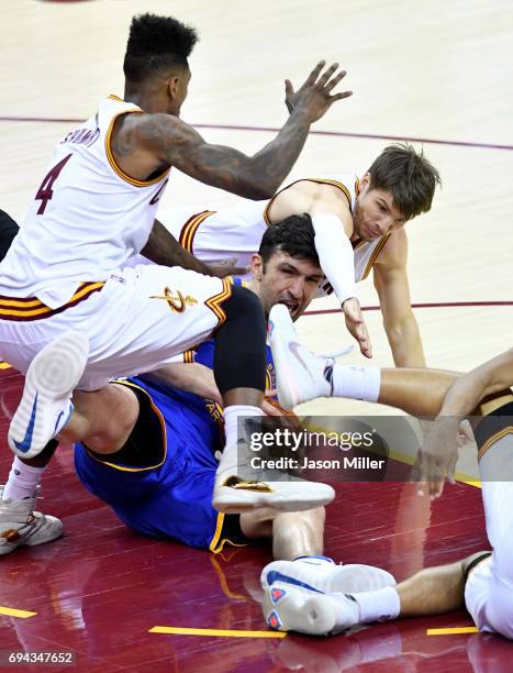 Iman Shumpert and Kyle Korver of the Cleveland Cavaliers compete for the ball with Zaza Pachulia of the Golden State Warriors in the third quarter in...