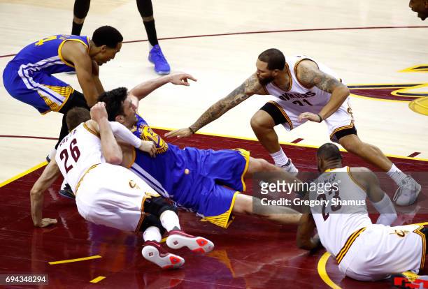 Zaza Pachulia of the Golden State Warriors gets tangled with Kyle Korver and Deron Williams of the Cleveland Cavaliers in the third quarter in Game 4...