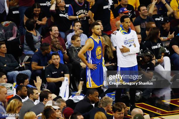 Stephen Curry and Shaun Livingston of the Golden State Warriors look on from the sideline late in the fourth quarter against the Cleveland Cavaliers...