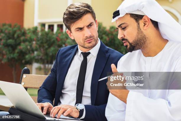 business executive having a conversation with an arabian businessman - bahrain people stock pictures, royalty-free photos & images