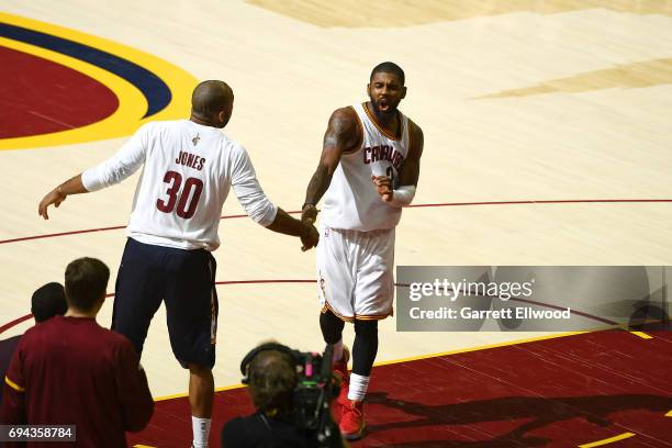 Kyrie Irving of the Cleveland Cavaliers high fives Dahntay Jones after defeating the Golden State Warriors in Game Four of the 2017 NBA Finals on...