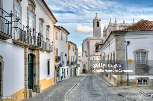 old town street and the capela dos ossos (chapel of bones) in évora, portugal. - capela dos ossos portugal stockfoto's en -beelden
