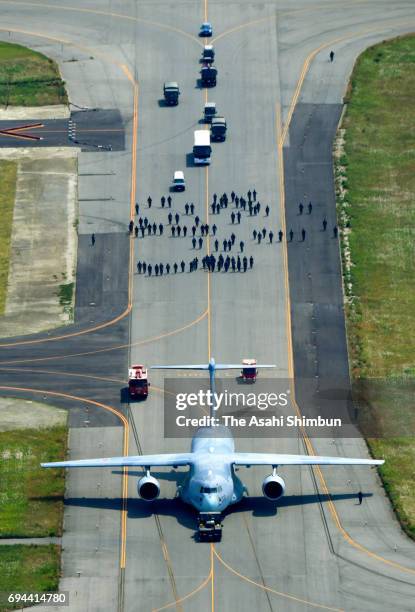 In this aerial image, a Japan Air Self-Defense Force C2 transport aircraft is towed after skidding off the runway at Tonago Airport on June 9, 2017...