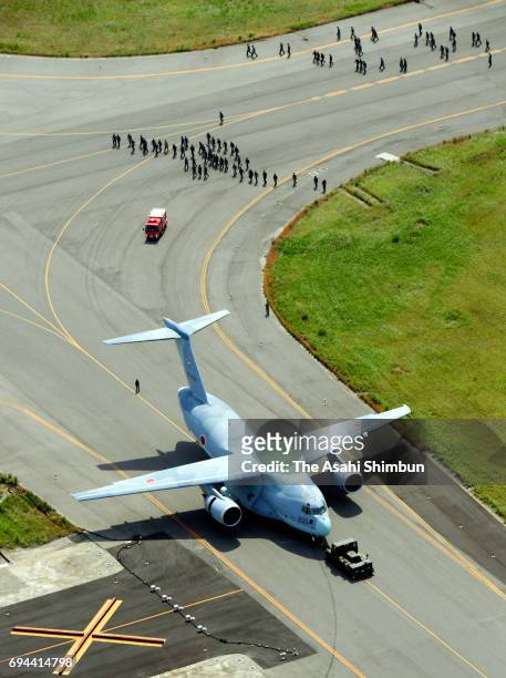 In this aerial image, a Japan Air Self-Defense Force C2 transport aircraft is towed after skidding off the runway at Tonago Airport on June 9, 2017...