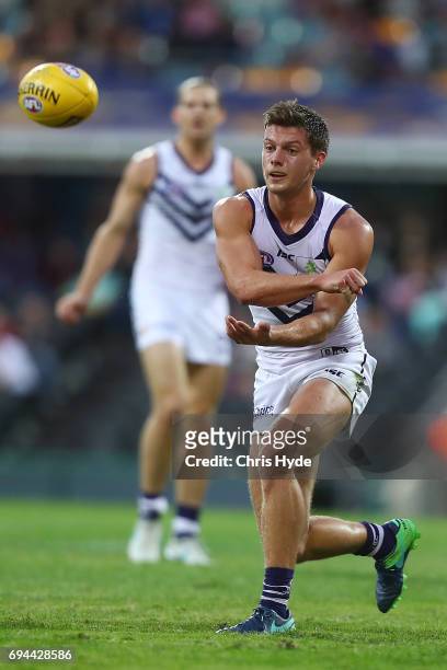 Darcy Tucker of the Dockers handballs during the round 12 AFL match between the Brisbane Lions and the Fremantle Dockers at The Gabba on June 10,...