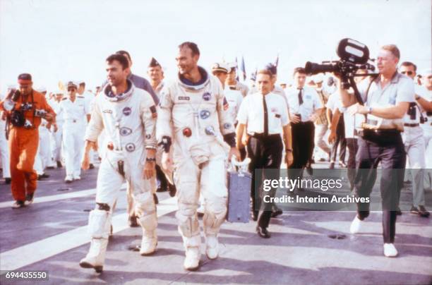 Astronauts John Young and Michael Collins walk on the deck of the recovery ship USS Guadalcanal upon returning to earth at the conclusion of the...