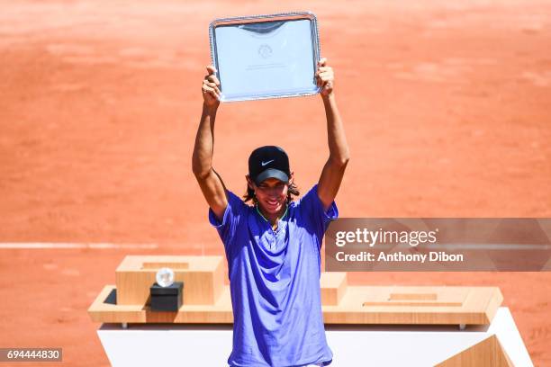 Alexei Popyrin of Australia celebrates his victory with the trophy during the day 14 of the French Open at Roland Garros on June 10, 2017 in Paris,...