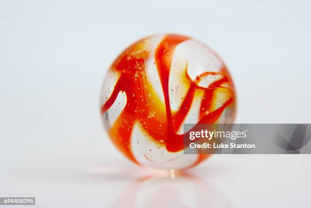 orange marble on a white background - murmel stock-fotos und bilder