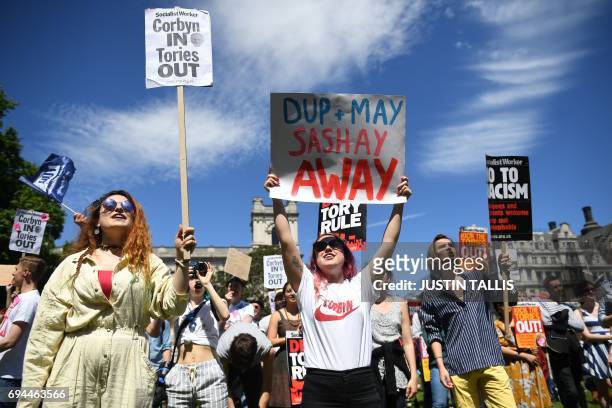 Anti-Conservative Party and anti-Democratic Unionist Party demonstrators gather with placards in Parliament Square in front of the Houses of...