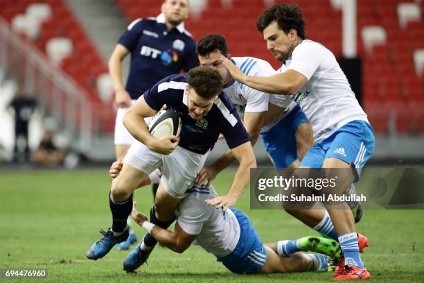 Duncan Taylor of Scotland is tackled during the International Test match between Italy and Scotland at Singapore Sports Stadium on June 10, 2017 in...