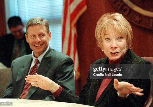 New Mexico Governor Gary Johnson listens as actress Shirley MacLaine speaks to reporters during a press conference in the governors office January...